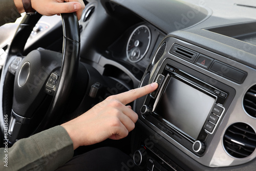 Choosing favorite radio. Man pressing button on vehicle audio in car, closeup © New Africa