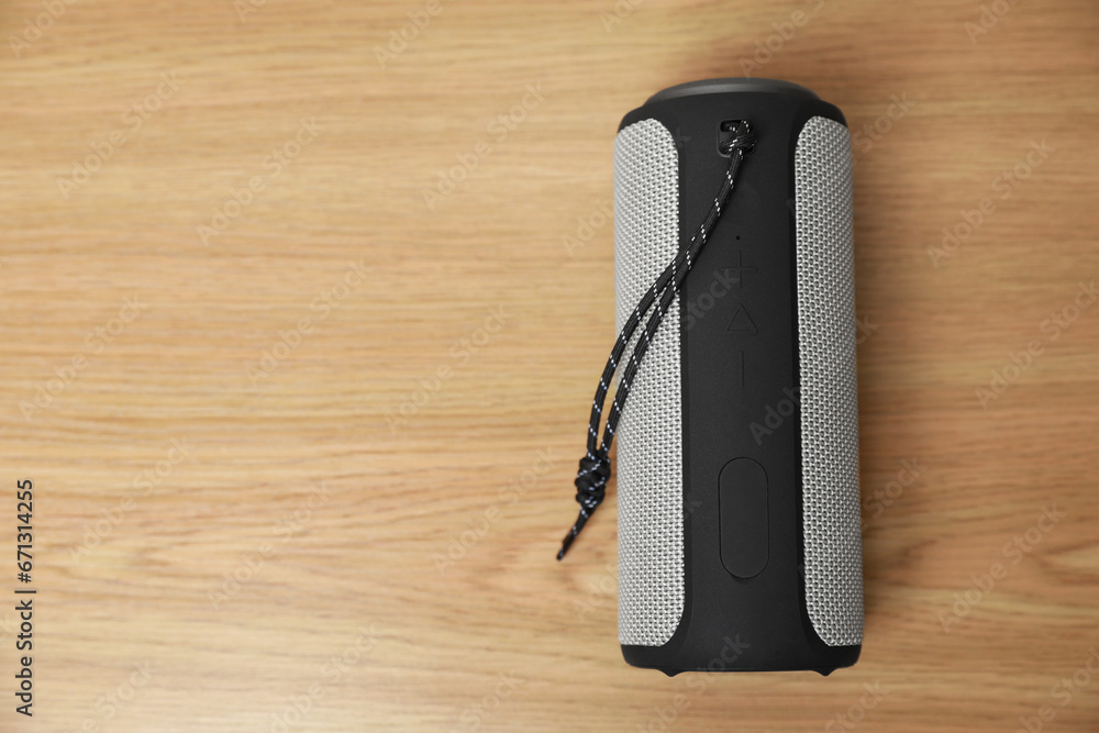 One portable bluetooth speaker on wooden table, top view with space for text. Audio equipment