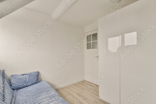 a bedroom with white walls and light wood flooring in the middle of the room  there is a bed on the right side