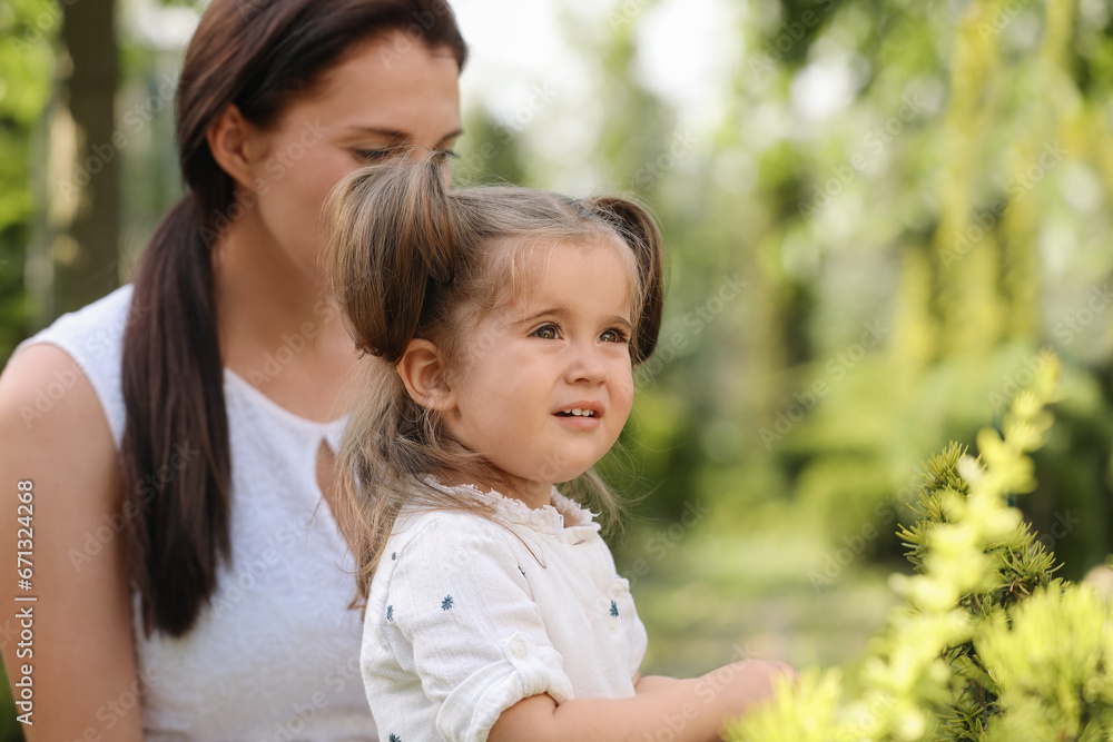 Mother with her cute daughter spending time together outdoors, space for text Mother with her cute daughter spending time together outdoors, space for text