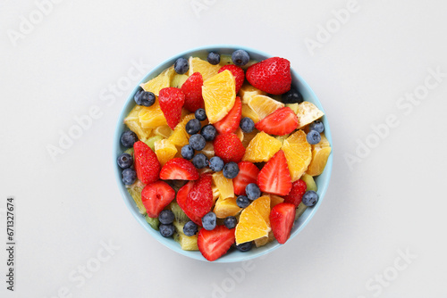 Yummy fruit salad in bowl on light grey background  top view