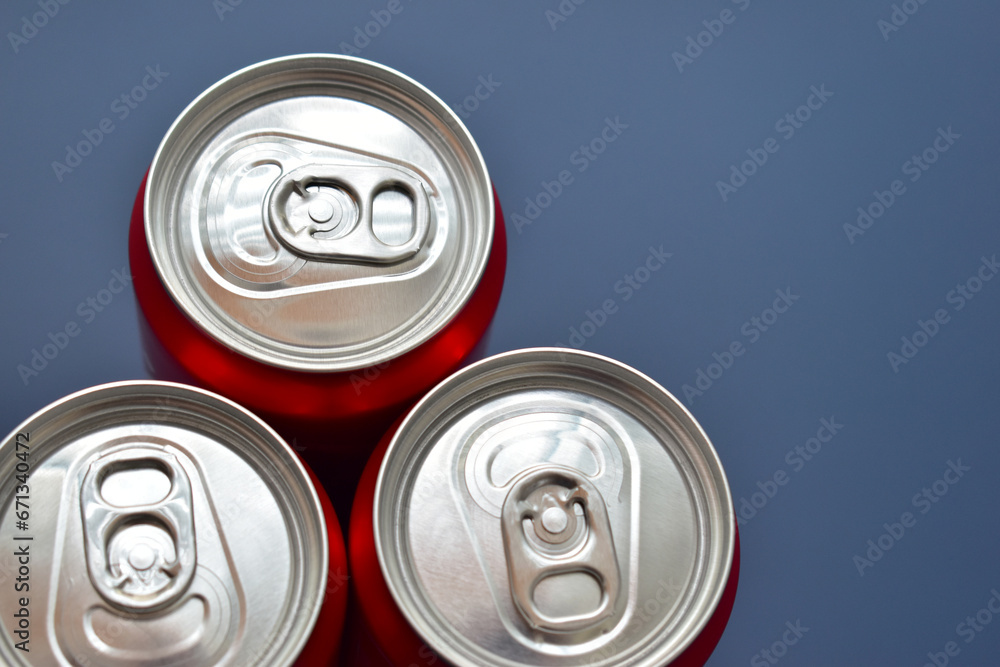 close up group of aluminium red cans soft drink put on blue texture background close up group of aluminium red cans soft drink put on blue texture background