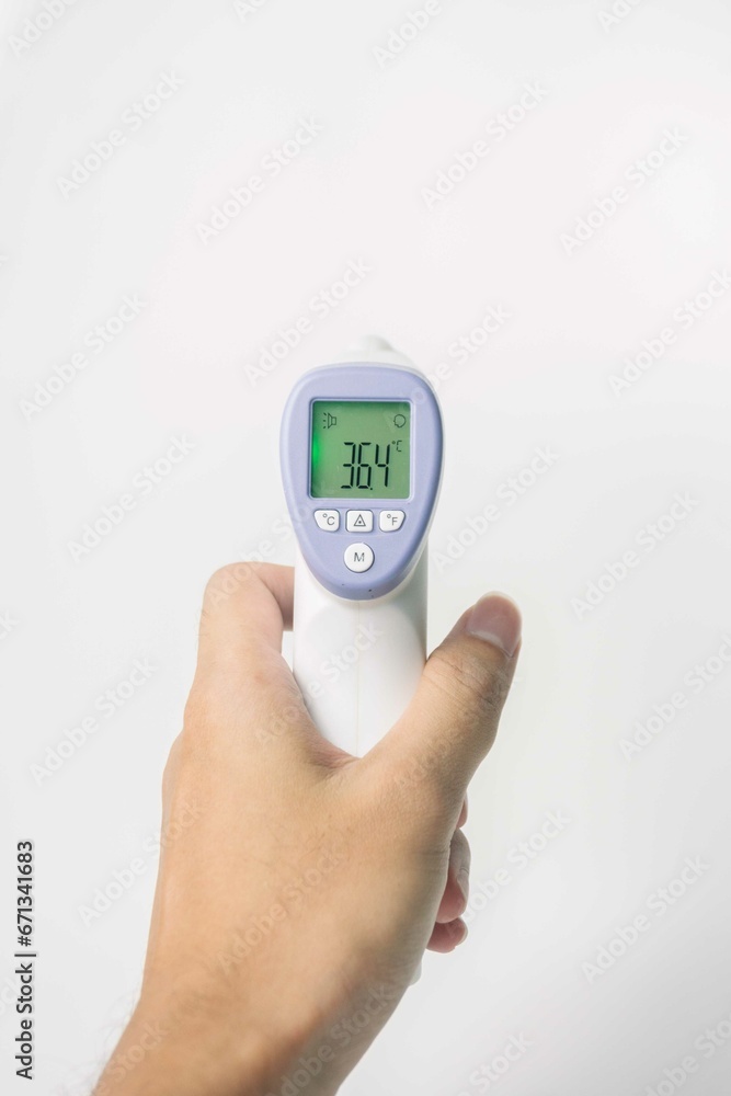 hand holding digital infrared thermometer isolated on white background. with copy space hand holding digital infrared thermometer isolated on white background. with copy space