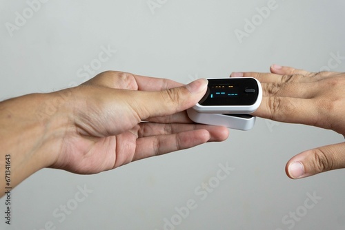 Close up of human finger while using Pulse Oximetry isolated on white background.