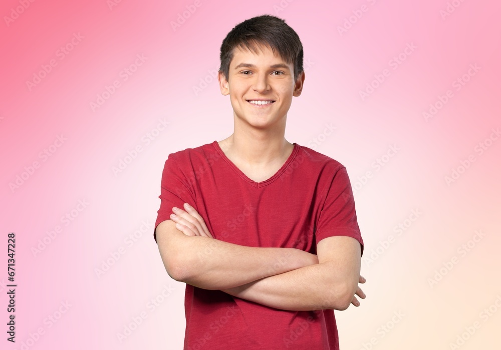 Fototapeta premium Happy young man standing with crossed arms
