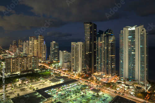 Aerial view of downtown district in Sunny Isles Beach city in Florida  USA. Brightly illuminated high skyscraper buildings in modern american midtown