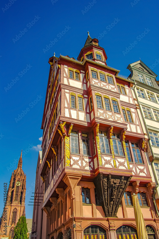 Frankfurt, Germany – Traditional German middle age timbered houses and Cathedral at historical downtown during colorful sunset. Cityscape of Romerberg square at blue sky and sunny day