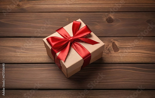 Gift box with red ribbon bow on wooden background © ZeNDaY