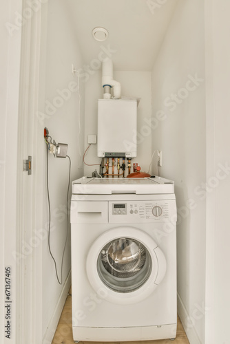 a white washer and dryer in a small laundry room with wood flooring on the left hand side