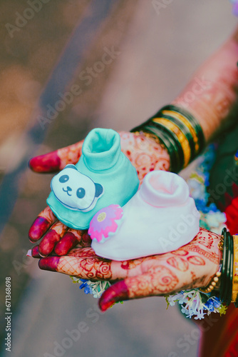 Mother Holding Tiny Girl Shoes Waiting for her Baby to Arrive. Pregnant woman receiving a gift for her daughter
