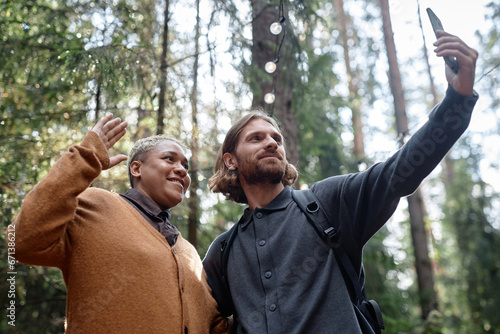 Multiethnic young couple making selfie portrait on smartphone outdoors © AnnaStills
