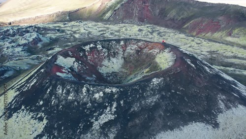 Aerial reverse view of red and green colored Icelandic Volcano that is a captivating and geologically significant features of the Highlands.  It has a majestic volcanic peak. photo