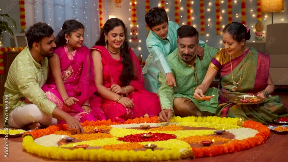 Group of Indian family members decorating Flower rangoli using Diya ...