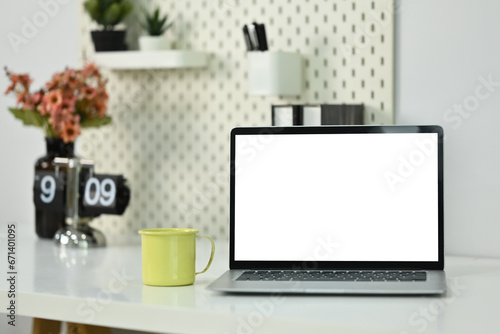 Home office desk with laptop, coffee cup and book. Empty display for your advertising text message