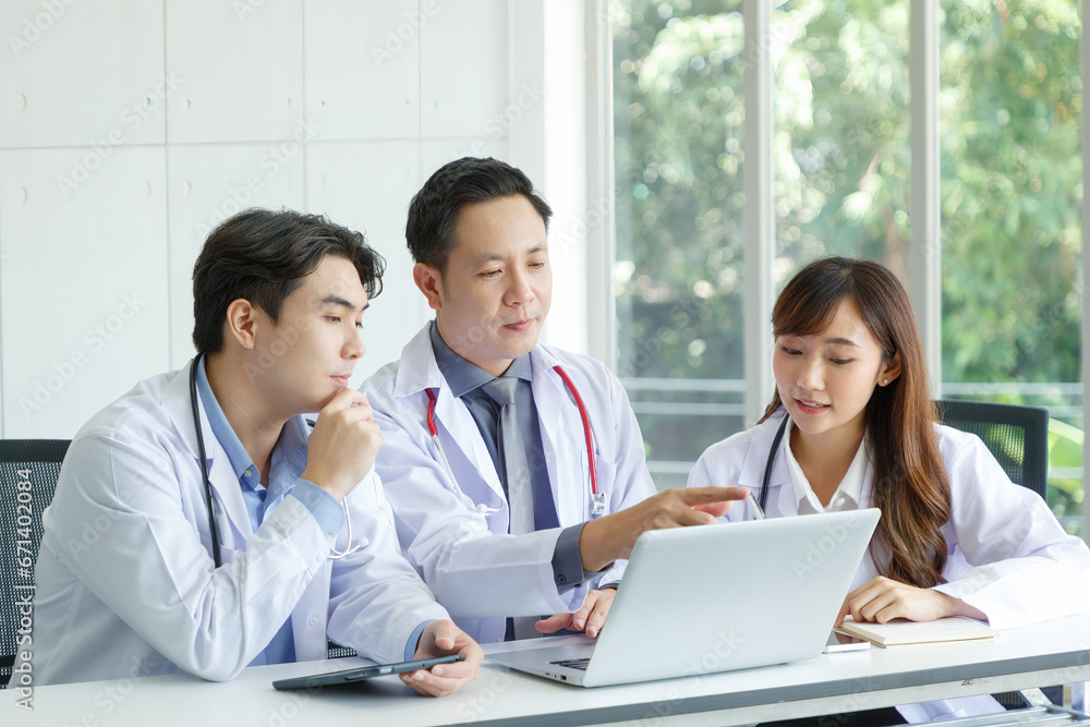 Young asian intern, young male and female doctor sitting with Senior Doctor talk and discuss using laptop in office. Young asian intern, young male and female doctor sitting with Senior Doctor talk and discuss using laptop in office.