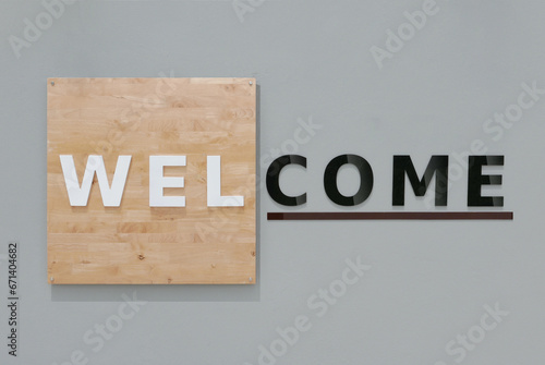 Welcome sign set on a wood background and grey cement