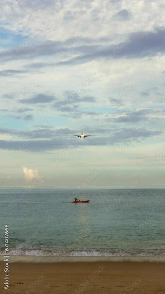 Passenger airplane before landing over tropical beach at morning. Vertical video Passenger airplane before landing over tropical beach at morning. Vertical video