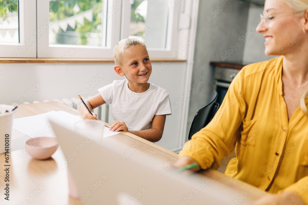 Fototapeta premium Mother is working from home and her son is drawing.