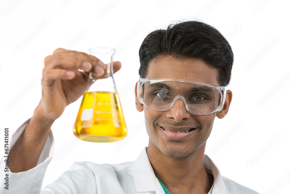 Young Indian lab technician holding a flask. Young Indian lab technician holding a flask.