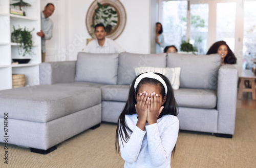 Hiding, counting and family playing a game in the living room for bonding, quality time and fun. Together, playful and child covering her eyes for hide and go seek with parents and siblings in lounge
