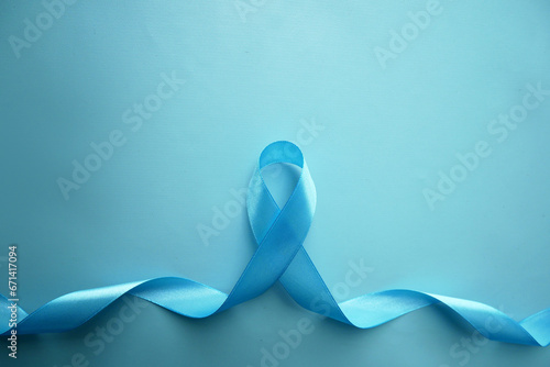 Blue awareness ribbon with the trail on a  blue background with copy space. Prostate Cancer Awareness, child abuse, diabetes.  photo
