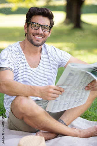 handsome man reading the newspaper at the park