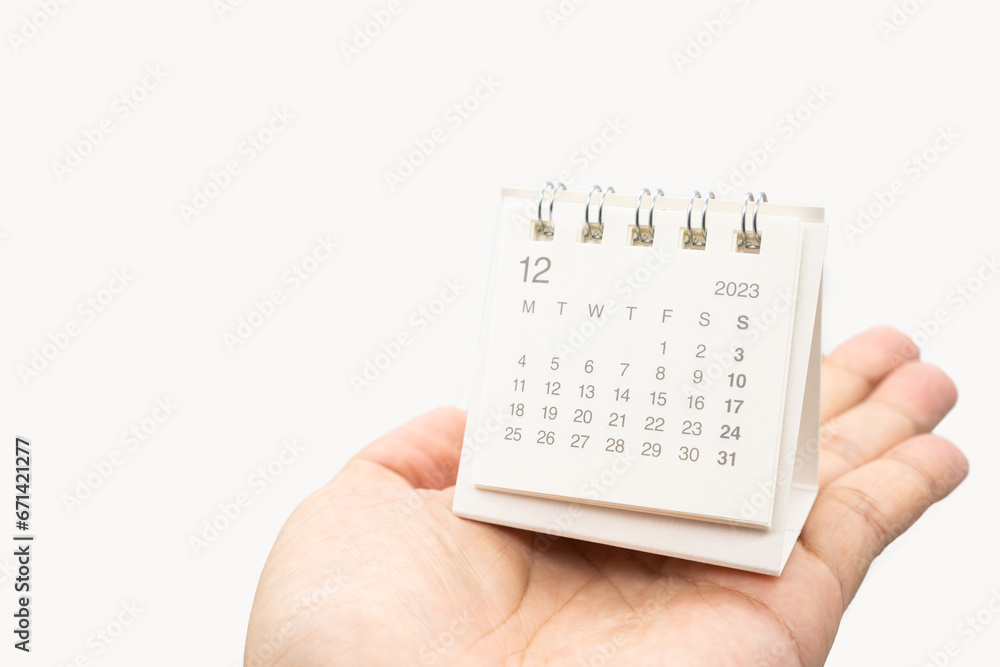 Simple desk calendar for December 2023 on palm isolated on white background. Calendar concept with copy space. - obrazy, fototapety, plakaty 