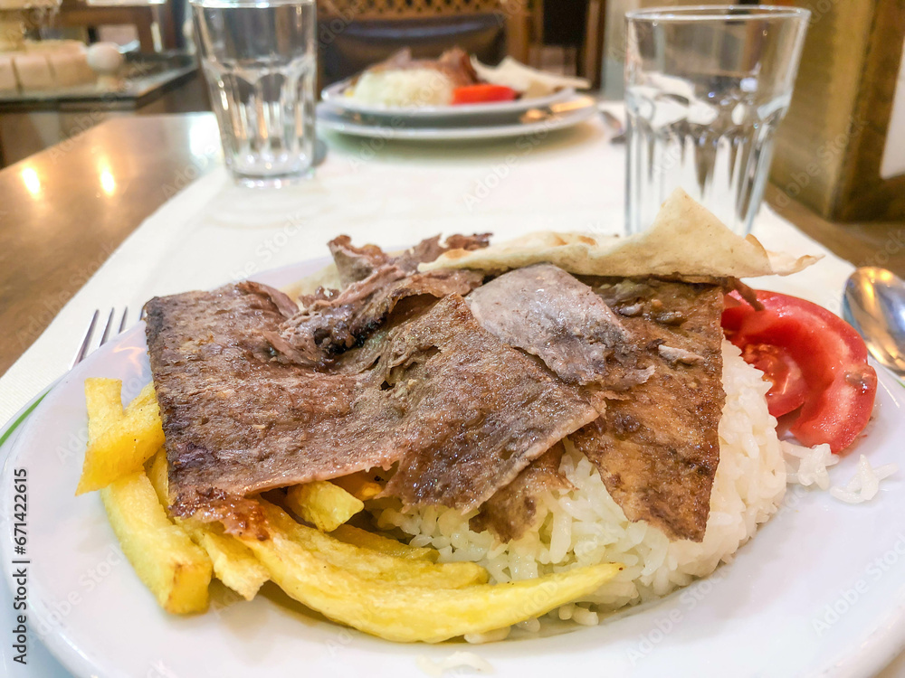 Traditional meat doner kebab on rice or turkish pilav on plate in turkey. Traditional meat doner kebab on rice or turkish pilav on plate in turkey.