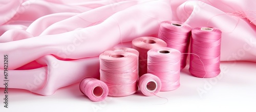 Selective focus on pink threads and fabric contrasting against a white background