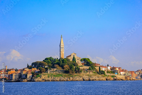 The old town of Rovinj with the church of St. Euphemia seen from the sea on a sunny day with blue sky © were