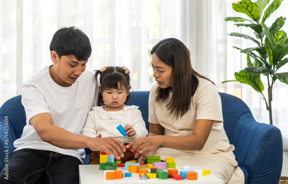 Portrait of enjoy happy love asian family father and mother with little asian girl smiling activity learn and skill brain play toy build wooden block board education game, children development at home Portrait of enjoy happy love asian family father and mother with little asian girl smiling activity learn and skill brain play toy build wooden block board education game, children development at home