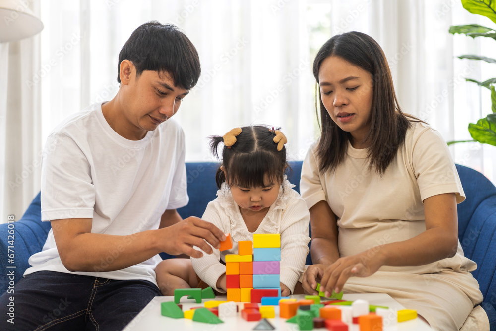 Portrait of enjoy happy love asian family father and mother with little asian girl smiling activity learn and skill brain play toy build wooden block board education game, children development at home Portrait of enjoy happy love asian family father and mother with little asian girl smiling activity learn and skill brain play toy build wooden block board education game, children development at home