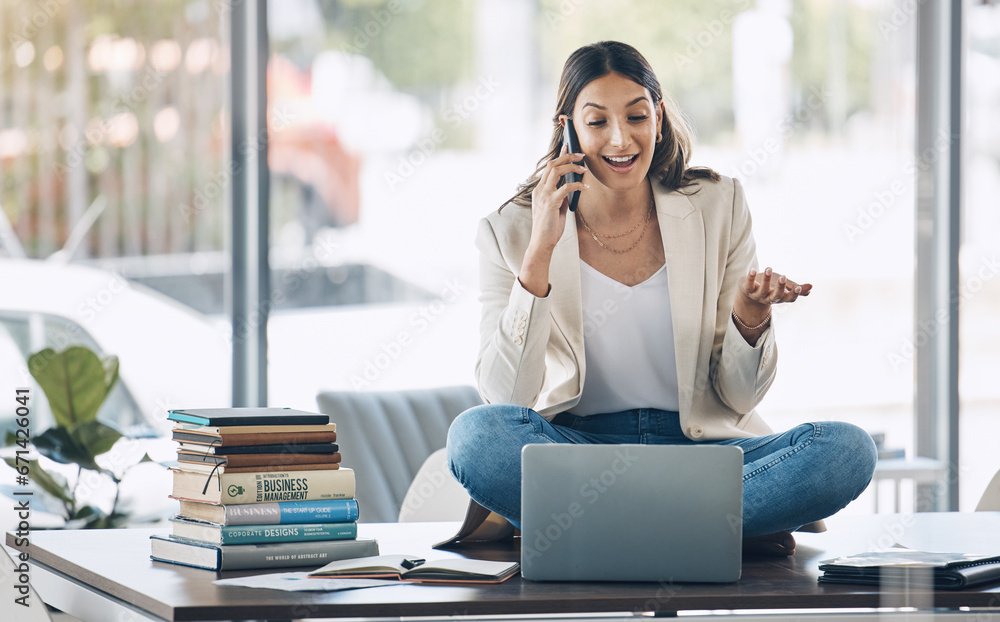 Obraz premium Worker, laptop and phone call and sitting on desk in relax startup, marketing company or advertising business. Smile, happy and talking woman on mobile communication technology, laptop or books study