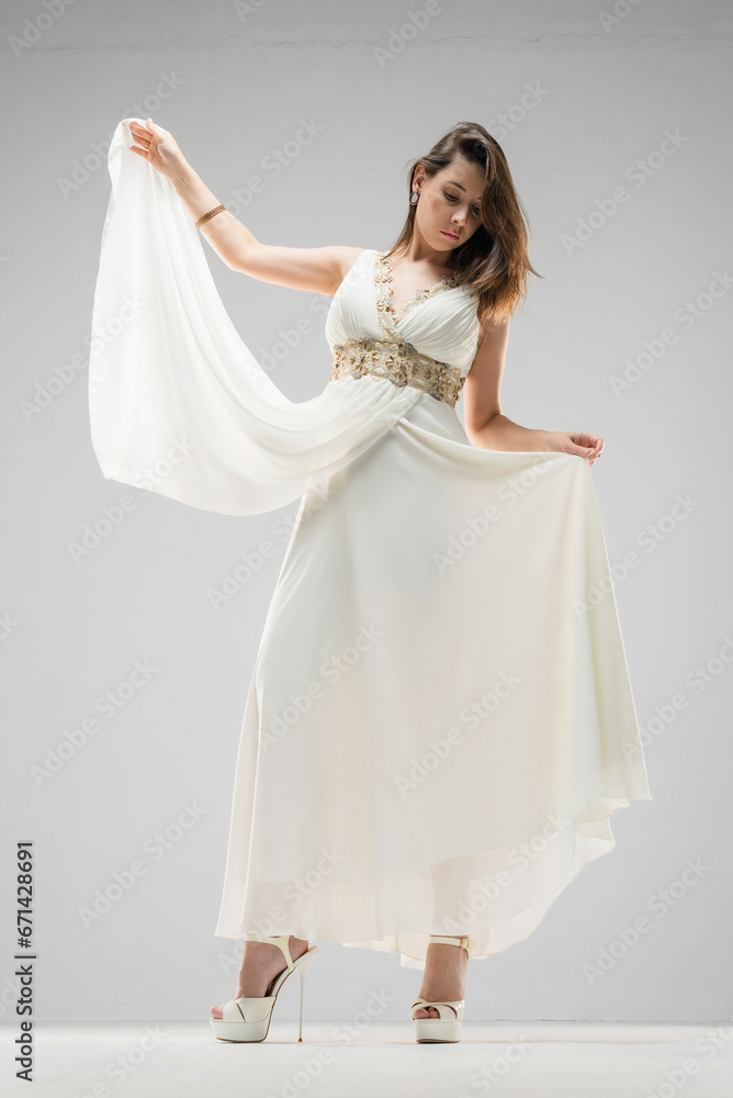 Obraz premium Woman in the retro style white dress posing on the white background.
