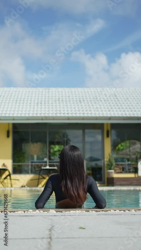 Video vertical woman standing by the pool