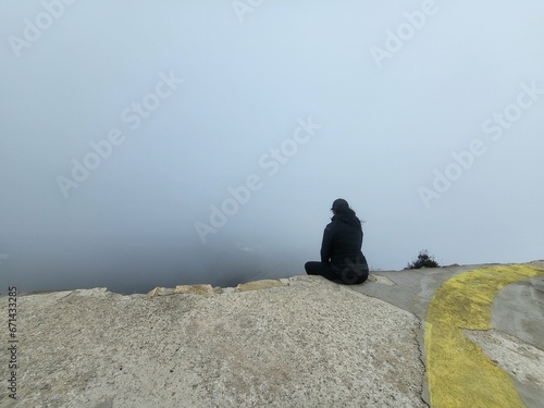 donna seduta su bordo nella nebbia photo