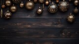 Christmas background with golden baubles on dark wooden planks with copy space