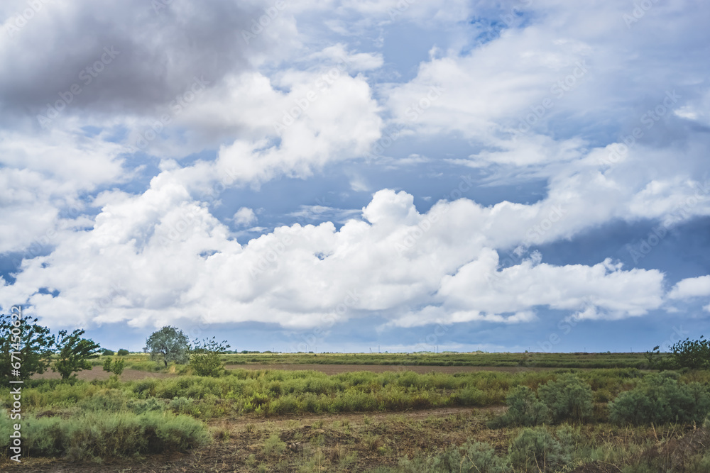 Panorama of a cloudy cloudy rain sky with cumulus clouds of various levels and fields