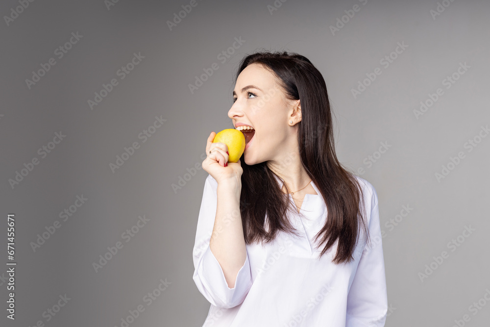 Portrait of woman promoting healthy eating. Beautiful young brunette woman holding fresh sliced lemon. Healthy eating lifestyle and weight loss concept. Studio white background.ac. High quality photo Portrait of woman promoting healthy eating. Beautiful young brunette woman holding fresh sliced lemon. Healthy eating lifestyle and weight loss concept. Studio white background.ac. High quality photo