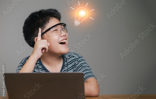 Asian Portrait of Smiling Schoolboy Ideas and Brainstorming Happy school student with a light bulb, nervous system, brain science, and learning Children's thought processes and psychology