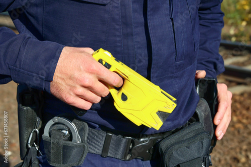 Tazer elektryczny w ręce policjanta. Paralizator photo
