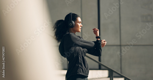 Runner woman, headphones and warm up on stairs for music, vision and ideas in city, workout and training. Girl, thinking and listen on steps with streaming subscription, wellness and stretching arms