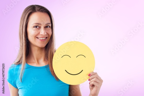 Happy teen girl holding emoji face