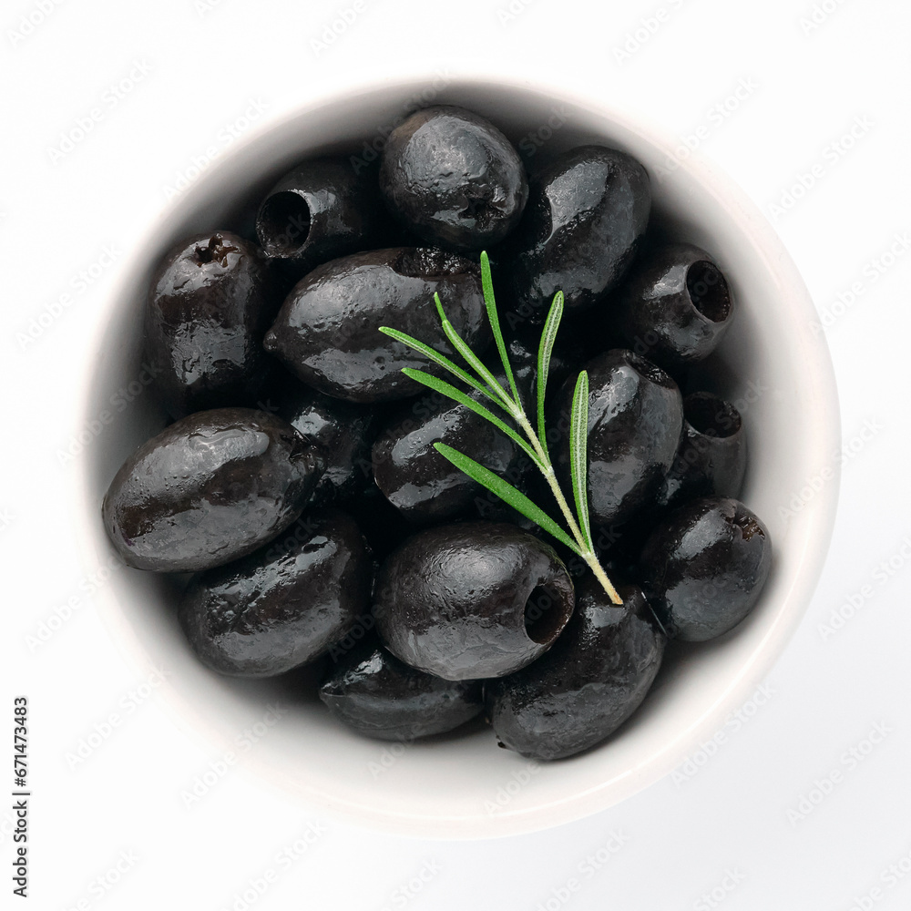 Delicious black olives in plate with olive tree sprig decoration isolated on white background top view for your design. Healthy eating, healthy fats for humans. Organic vegetable Delicious black olives in plate with olive tree sprig decoration isolated on white background top view for your design. Healthy eating, healthy fats for humans. Organic vegetable