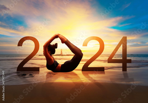 Happy new year card 2024. Silhouette of healthy girl doing Yoga Bow pose on tropical beach with sunset sky background, woman practicing yoga as a part of the Number 2024 sign.