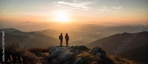 Hikers enjoy the view of the sunrise from the top of the mountain