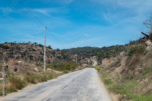 Entre montes uma estrada asfaltada com alguns postes de eletricidade a seguir a mesma em Trás os Montes, Portugal