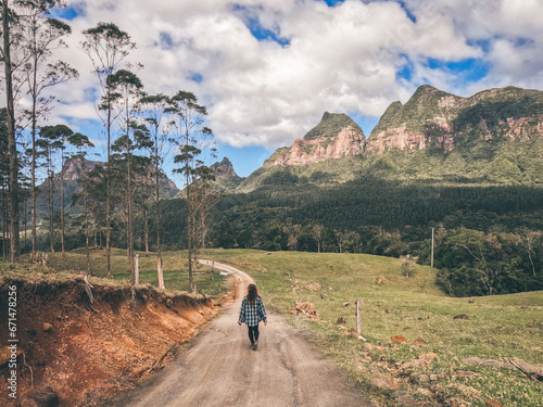 mulher caminhando em frente a montanhas de região conhecida como pirâmides sagradas em grão pará, santa catarina, no parque estadual serra furada photo