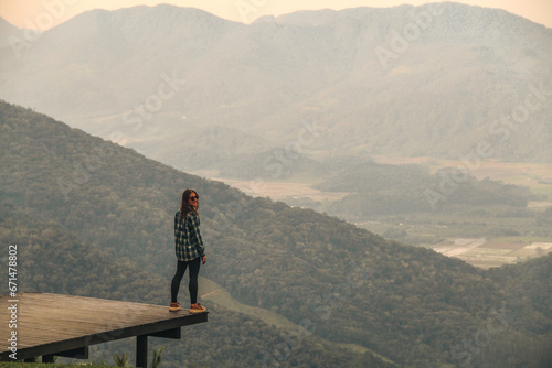 mulher em mirante com montanhas ao fundo em rio dos cedros, santa catarina  photo
