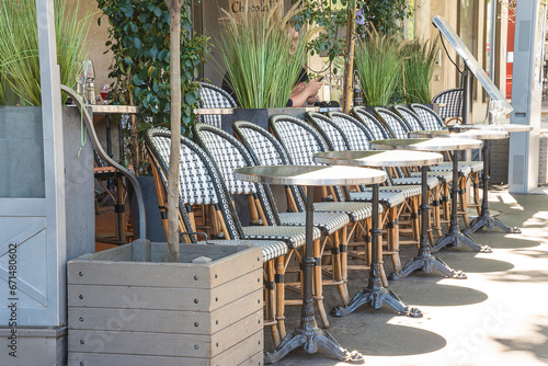 Runk of chairs and tables in the french restaurant on sunny summer photo